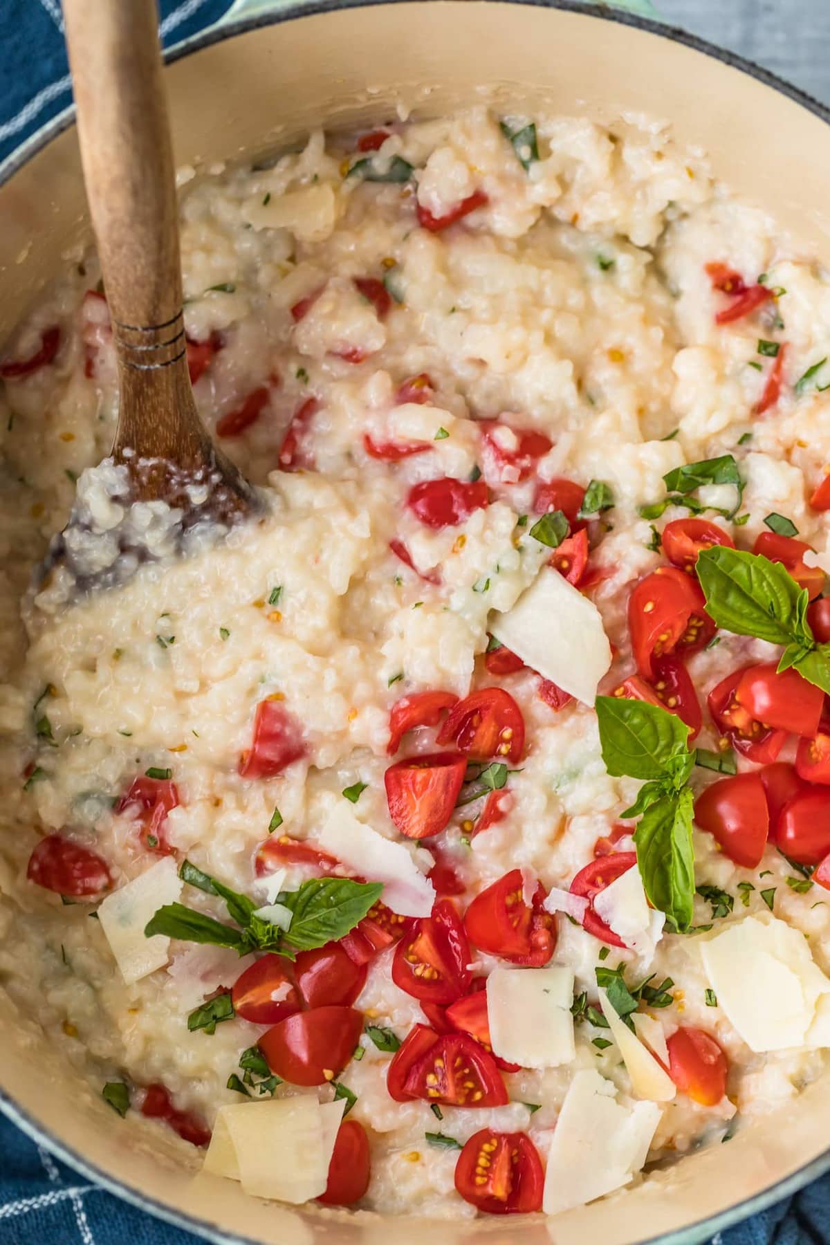 Close up of tomatoes and basil being added to the rice