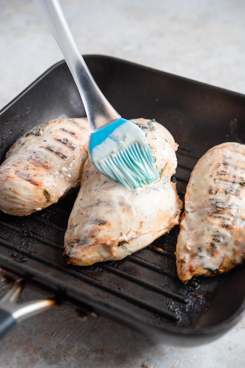 Brushing tequila lime chicken with ranch dressing