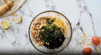 A bowl of cowboy caviar on a marble table.