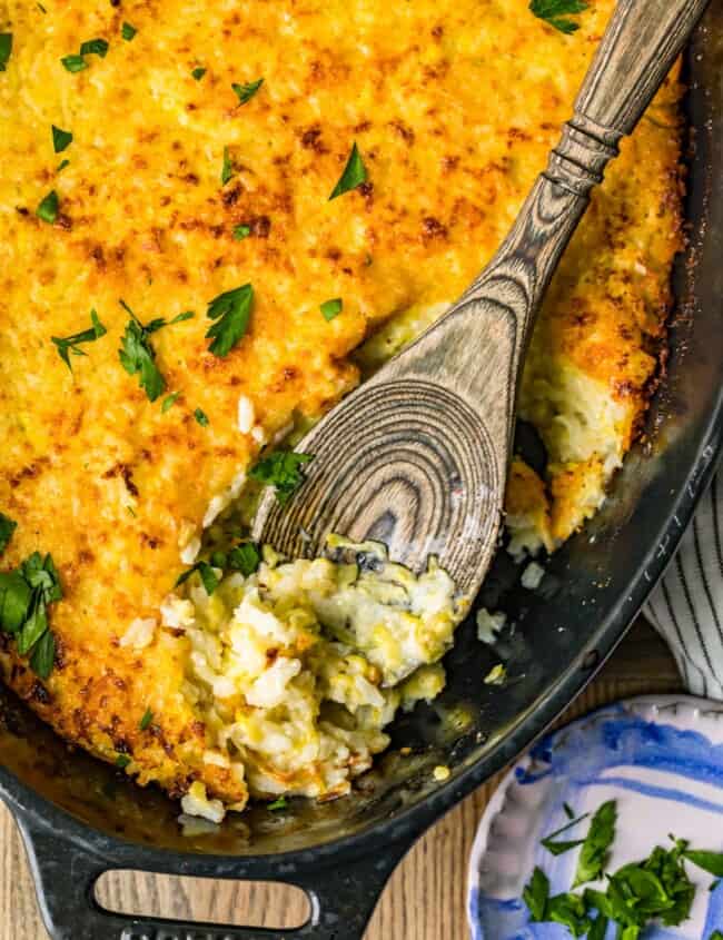 zucchini gratin in pan with wooden spoon