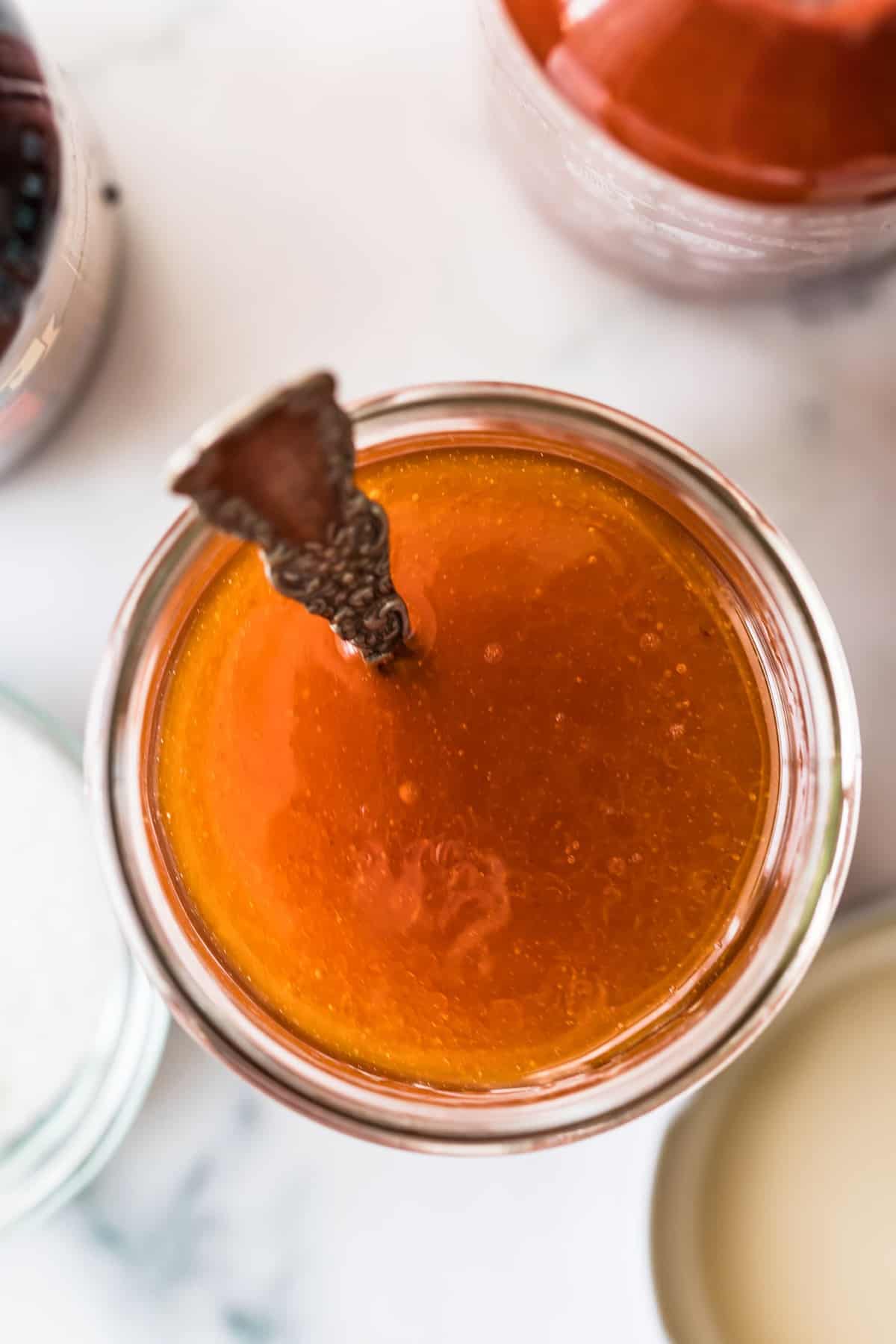 Top shot of the vinaigrette in a glass jar with a spoon