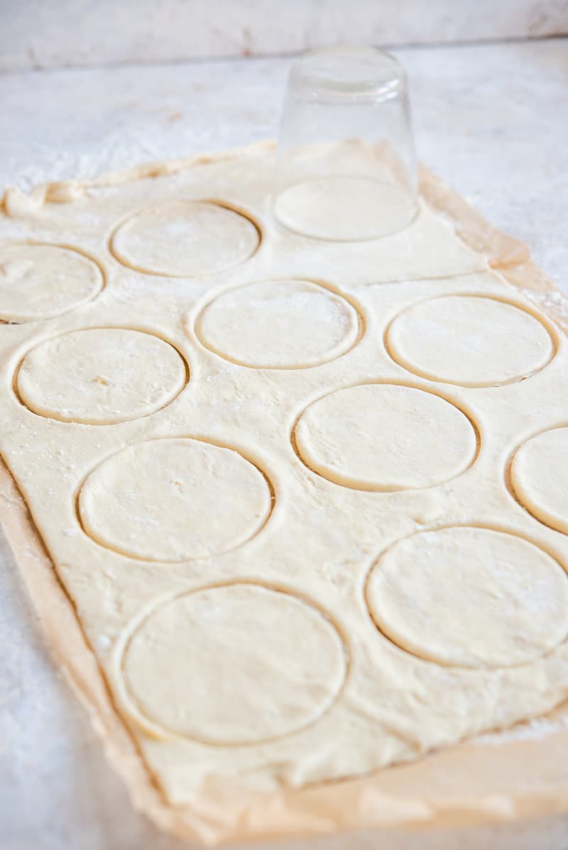 A process shot of cutting out pastry circles with a glass.