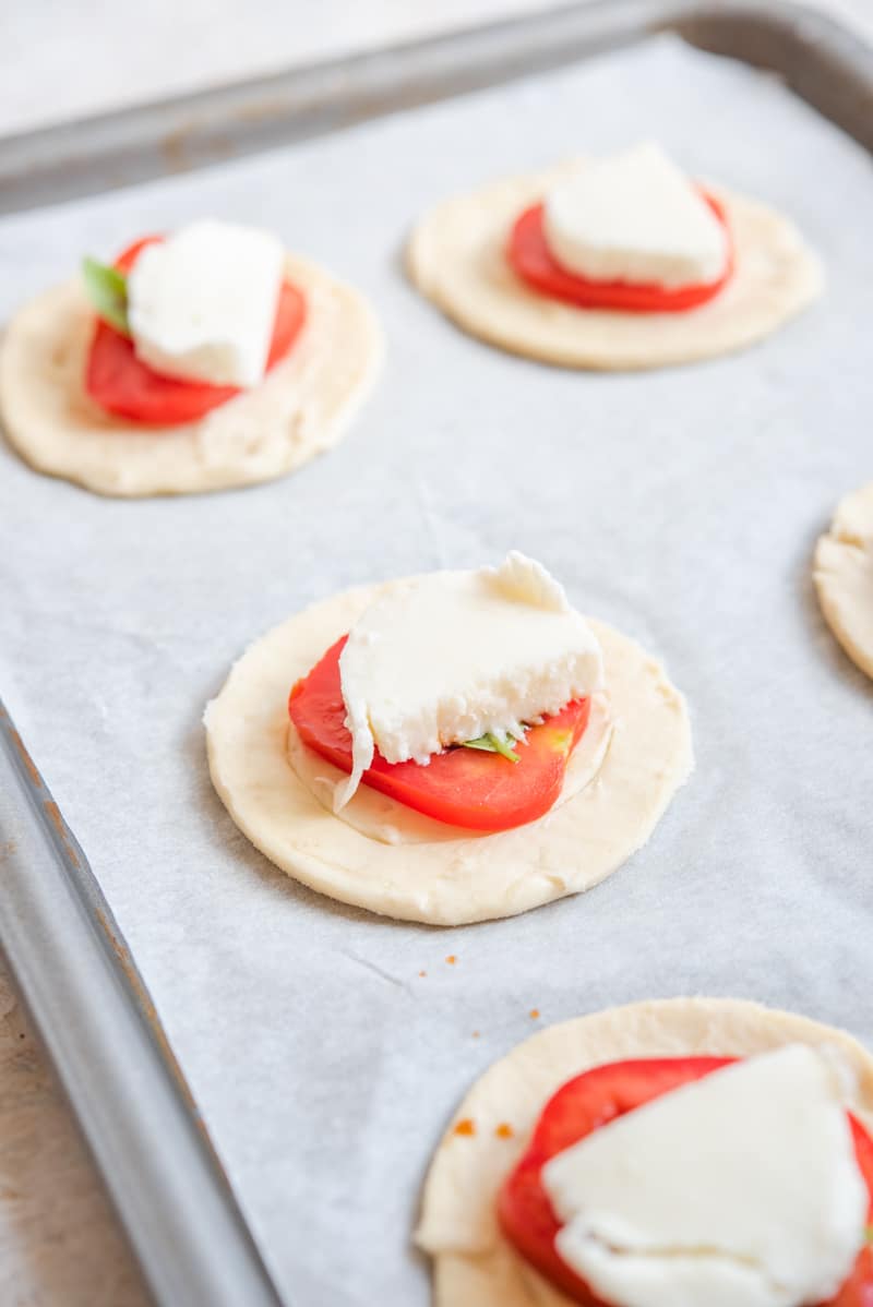 Unbaked Mini Caprese Tarts on a baking tray.