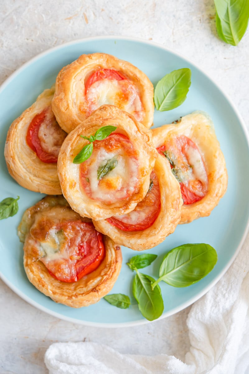 An overhead shot of Mini Caprese Tarts on a blue plate.