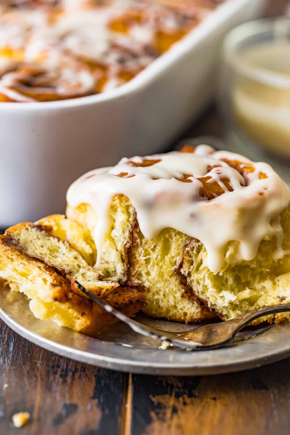 A Homemade Cinnamon Roll with icing on a plate