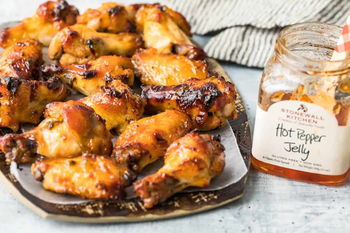 Wings on a plate next to the red pepper jelly