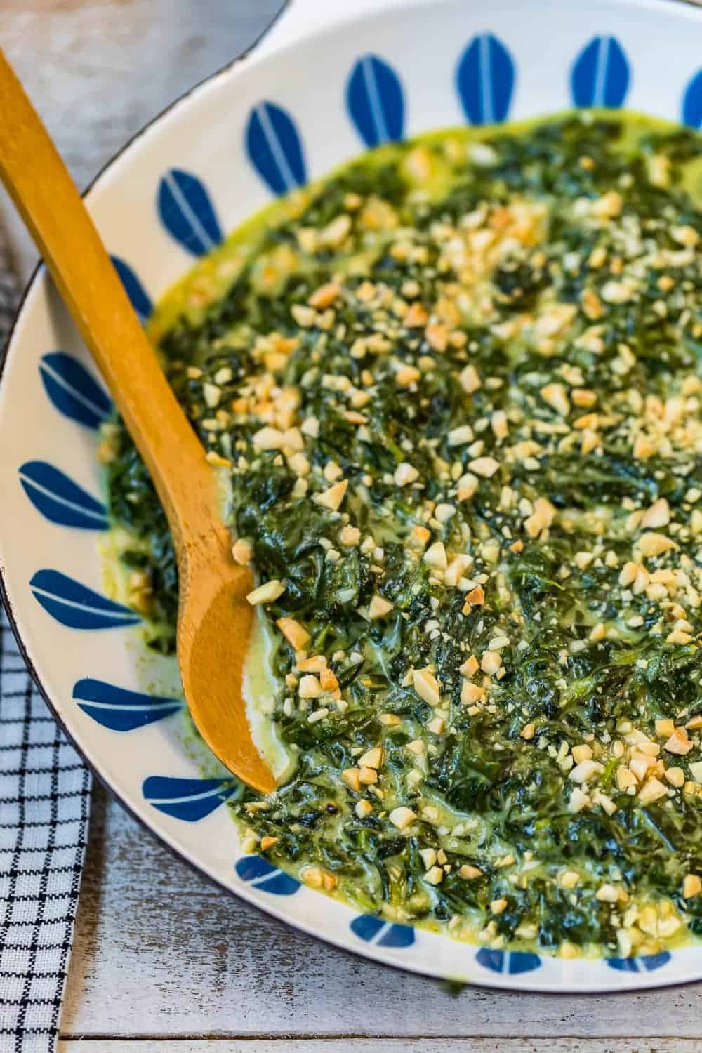 A wooden spoon in cooked creamed spinach