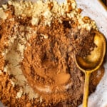 Chocolate powder sprinkled in a bowl with a spoon.