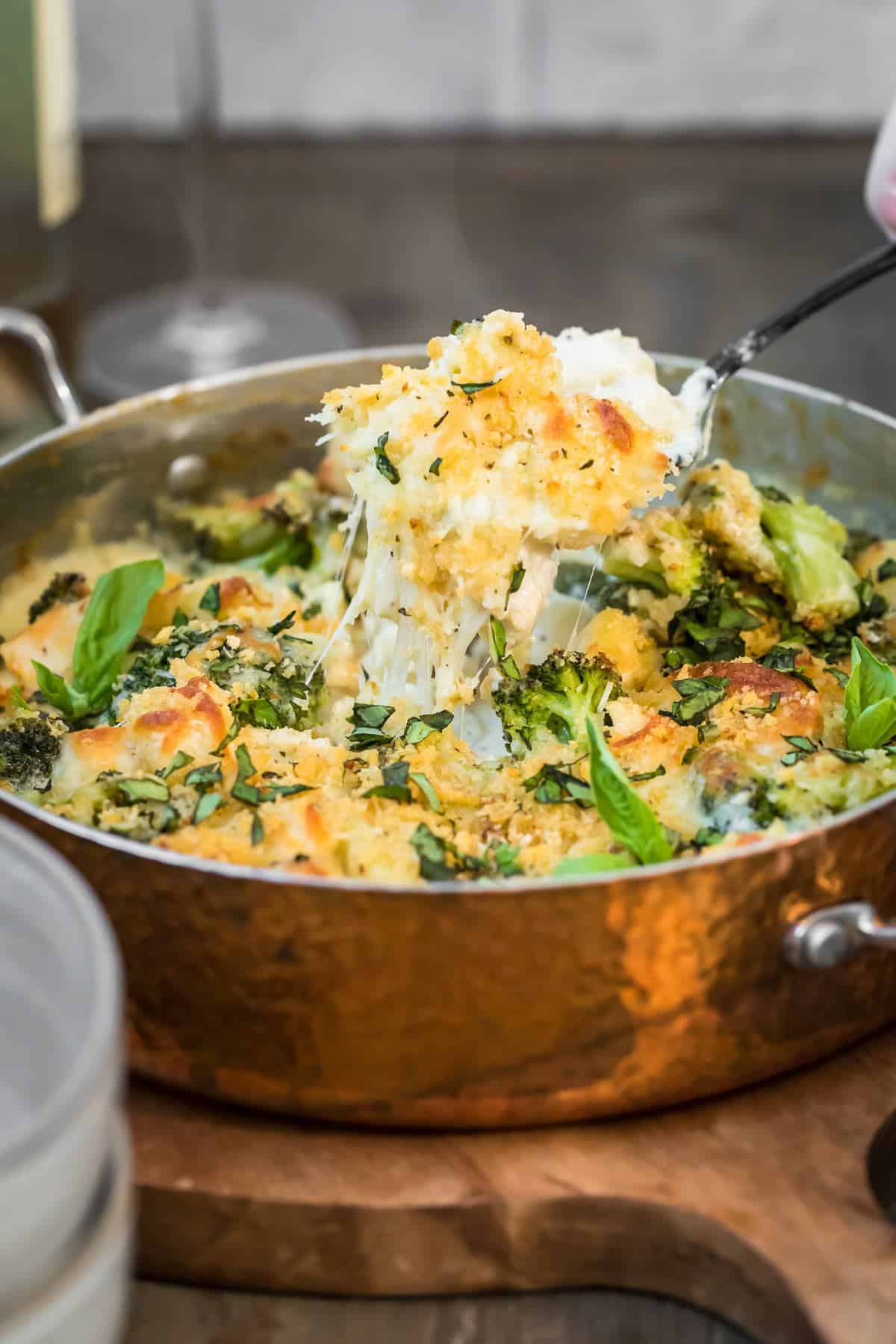 View of cheesy Chicken Alfredo Gnocchi Bake being pulled up from pan