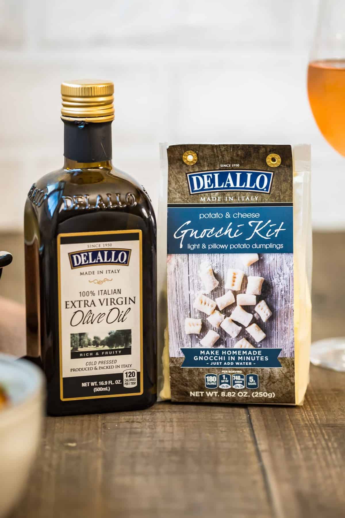 Delallo extra virgin olive oil bottle and Delallo Gnocchi Kit on wooden table