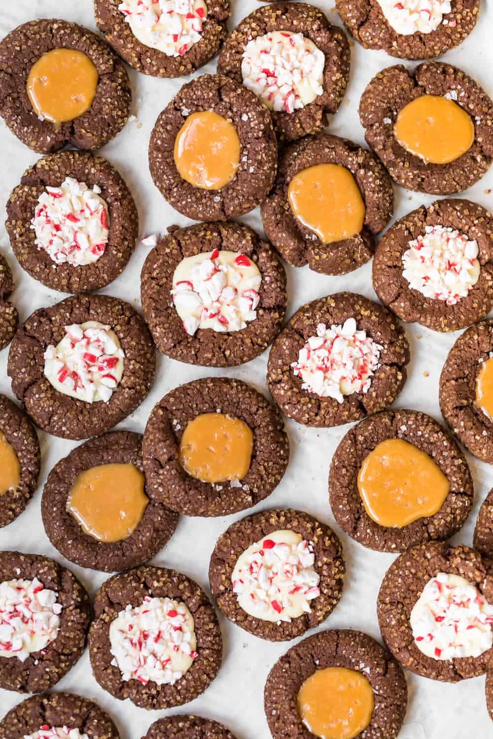 chocolate thumbprint cookies with a peppermint twist on a baking sheet.