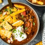 crockpot chili in a bowl with spoon with crackers