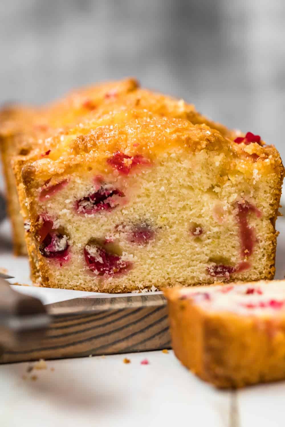 Glazed Lemon Cranberry Bread on a wooden chopping board