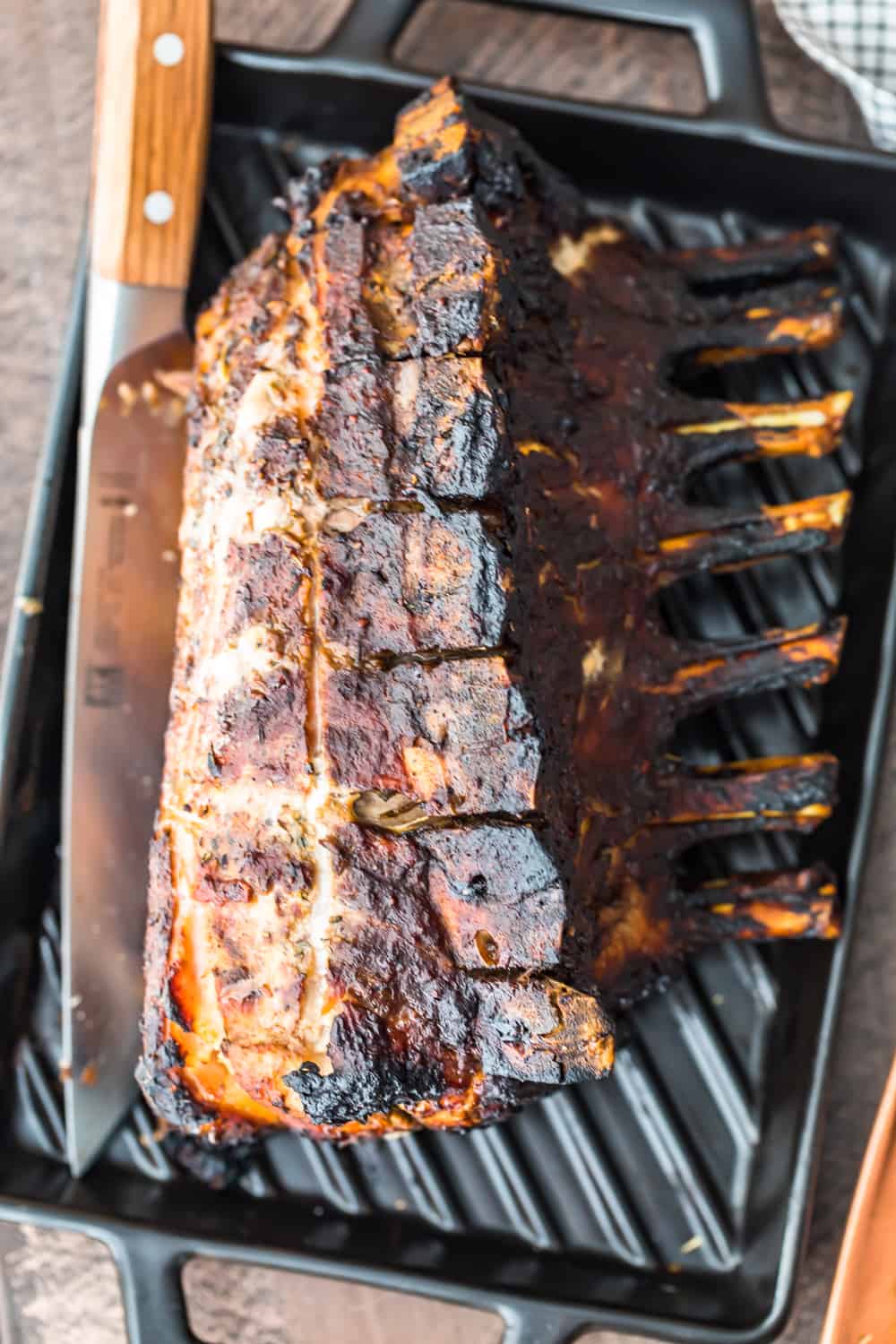 pork roast lying on a baking pan with a carving knife