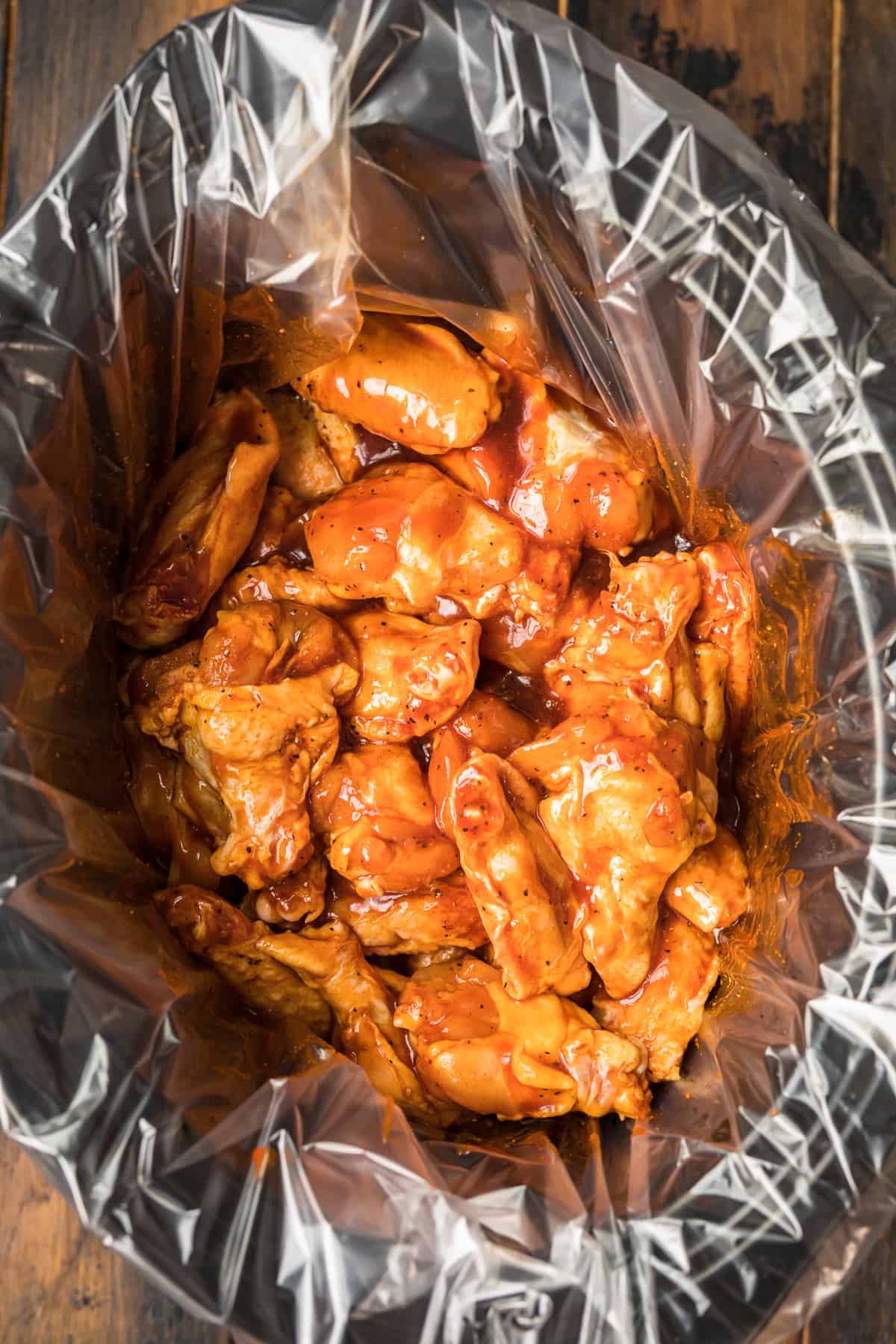 top view of crock pot with liner and chicken