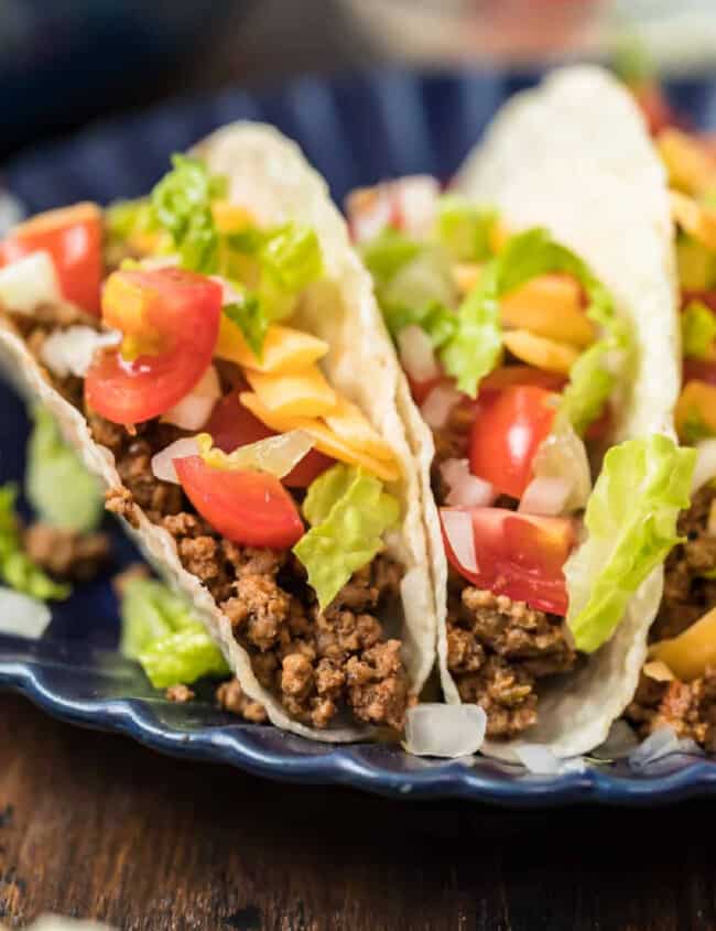 A plate of tacos with crockpot taco meat and vegetables.