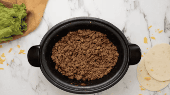 Crockpot beef tacos with guacamole and tortillas.