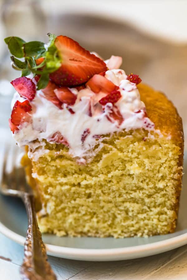 Close up of a slice of the cake with strawberries and cream topping