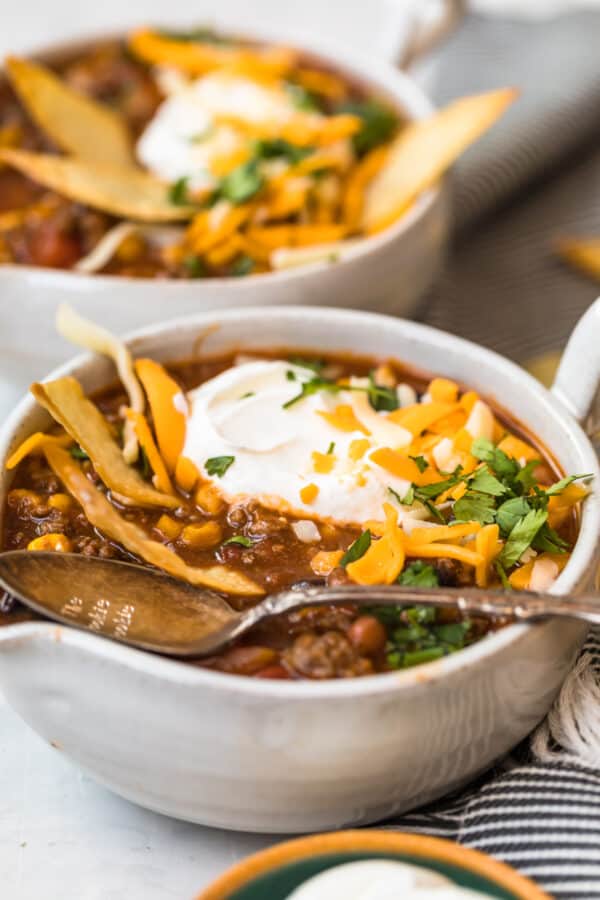 Sour cream shredded cheese and fresh herbs on top of the soup