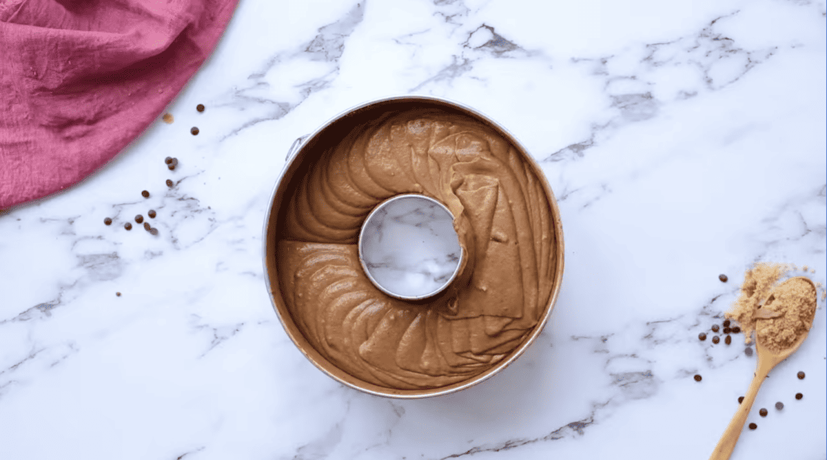 A chocolate brownie batter in a pan with a spoon.