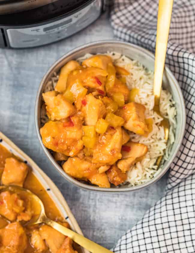 sweet and sour chicken in a bowl with a fork and rice