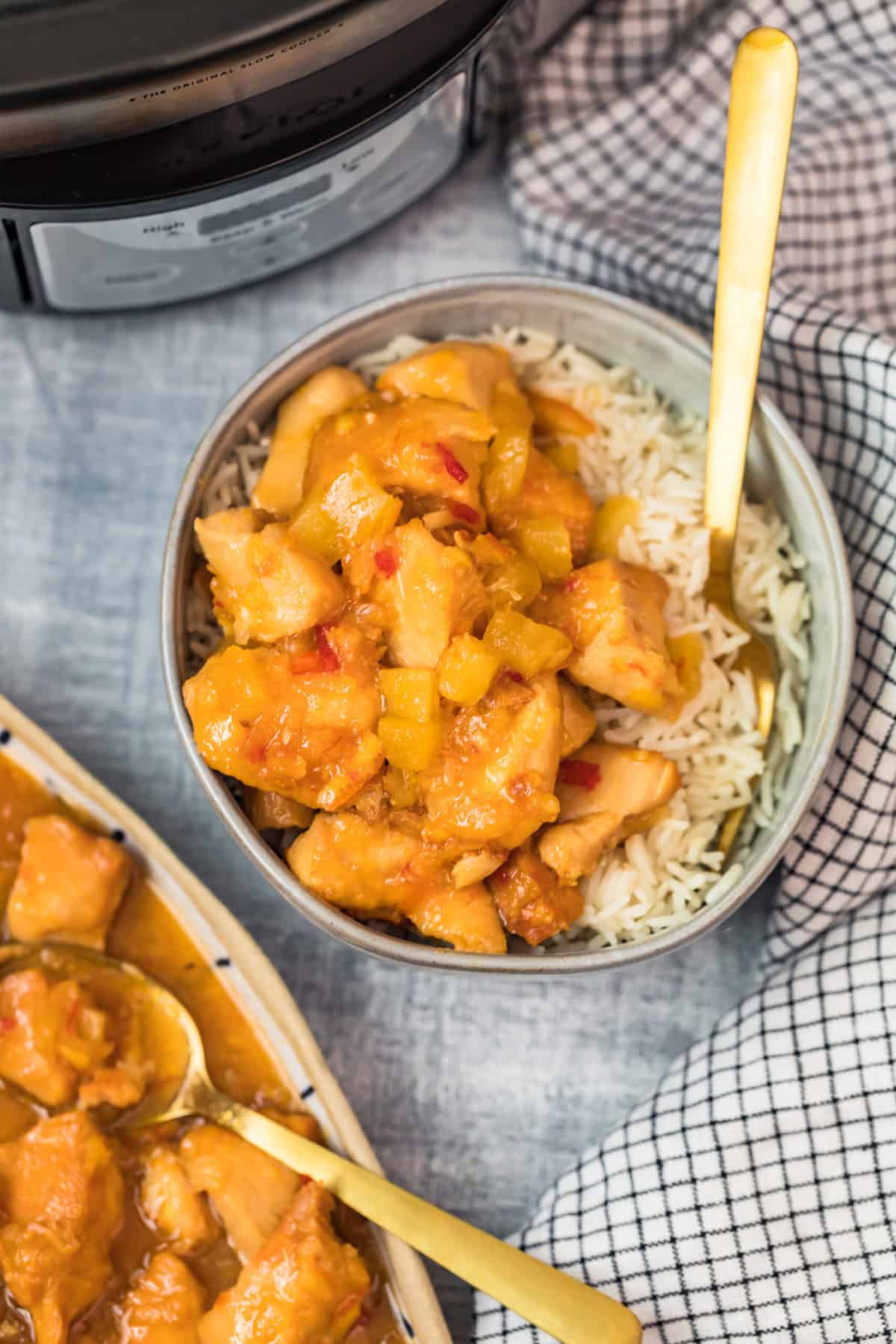 sweet and sour chicken with rice in a bowl with a fork