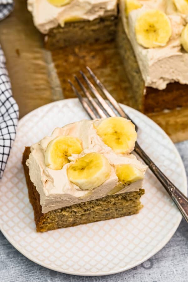 slice of banana cake with whipped cream and bananas