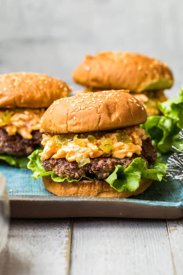 side shot of pimento cheeseburgers on blue platter