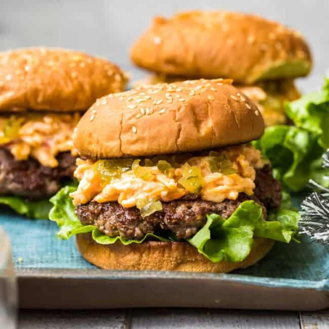 side shot of pimento cheeseburgers on blue platter