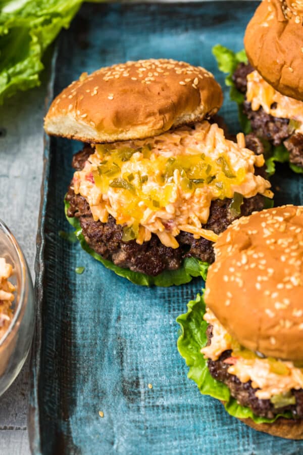 burger topped with pimento cheese and relish with bun half on