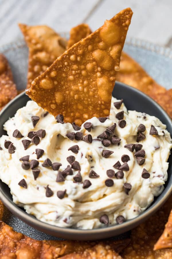 wonton chip dipping in cannoli dip with chocolate chips