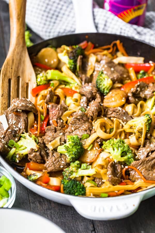 side image of beef lo mein with wooden spoon