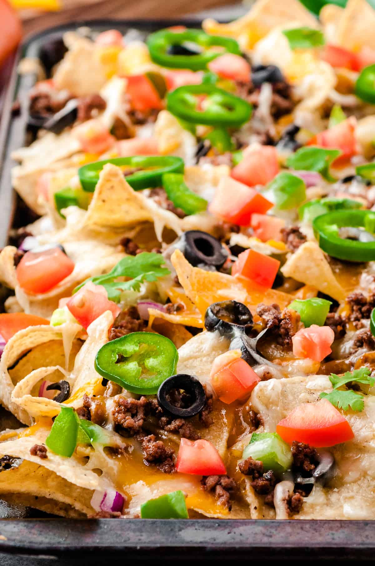 side image of beef nachos on sheet pan