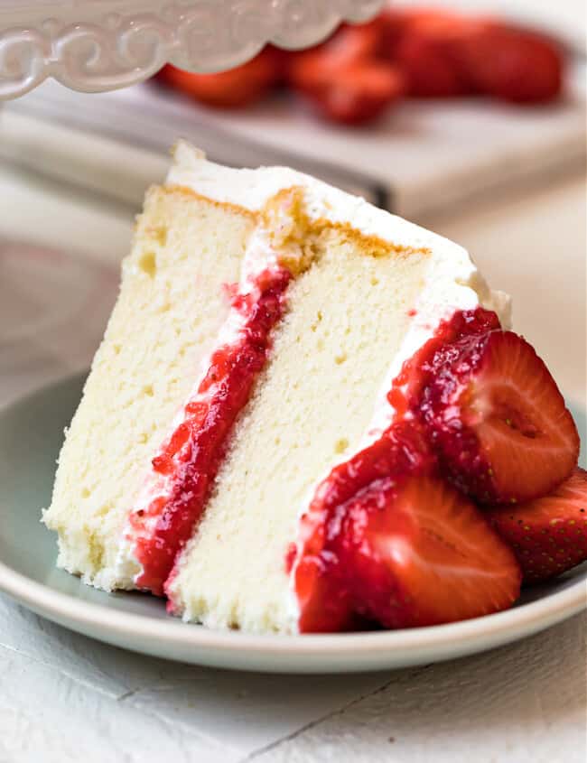 slice of white cake with strawberry filling and whipped cream frosting