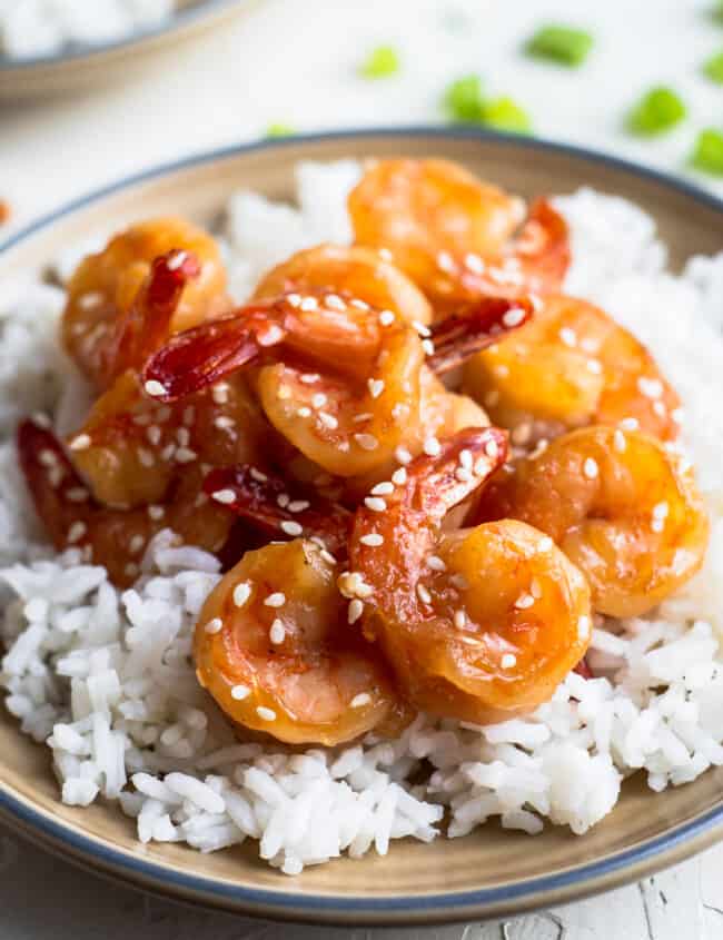 honey sesame shrimp over rice on brown plate