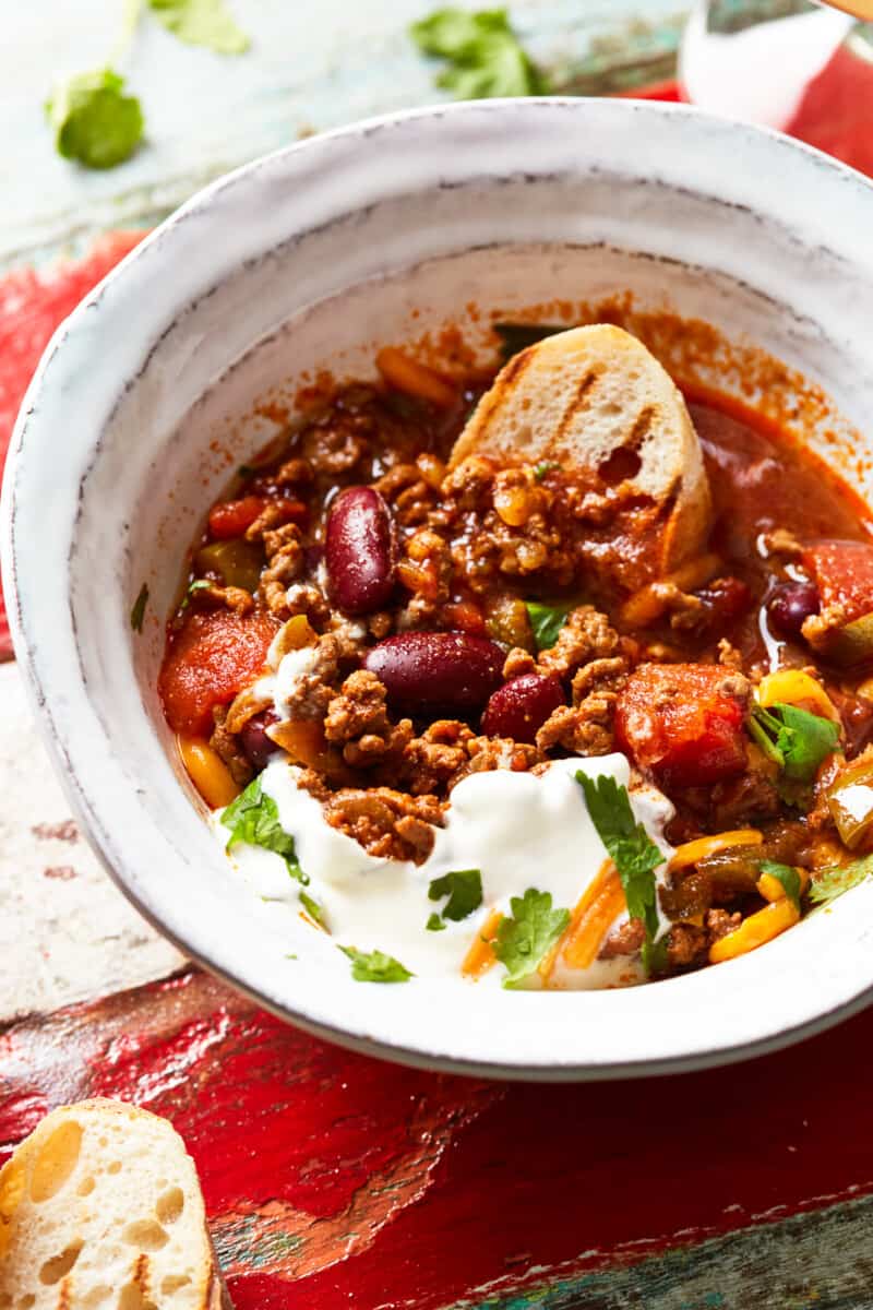 bowl of instant pot chili garnished with cheese and sour cream