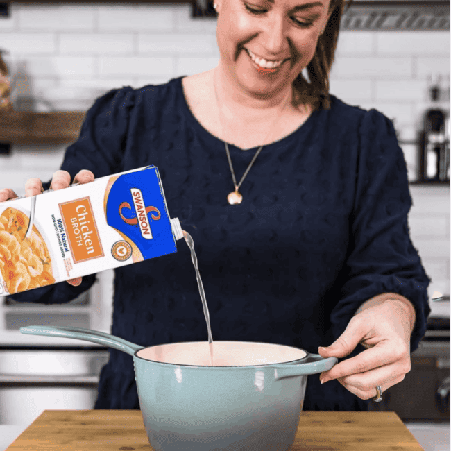 A food blogger pouring liquid into a pot.