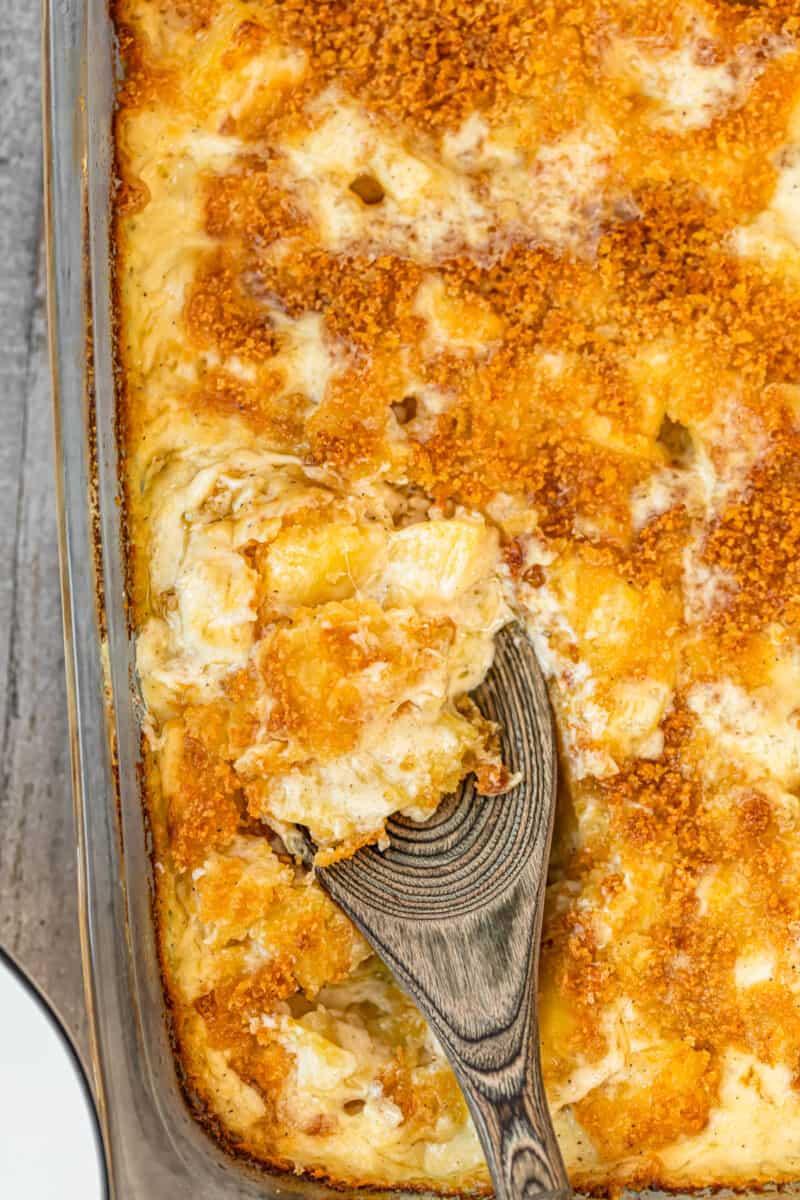 spoon digging into cheesy creamed potatoes