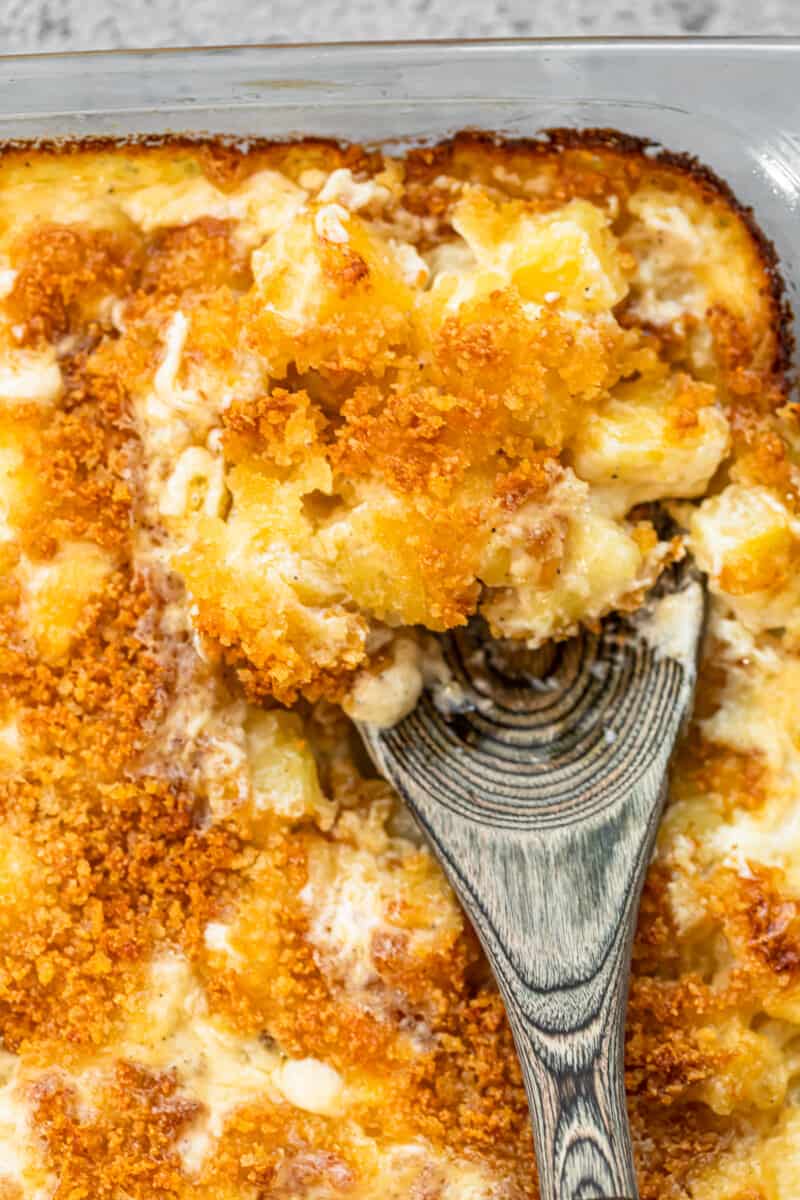 spoon digging into cheesy creamed potatoes