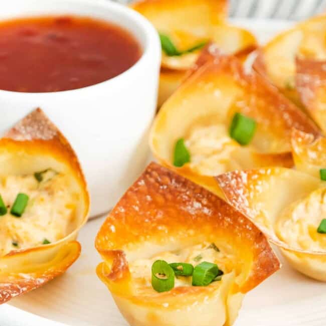 baked crab rangoon bites next to dipping sauce