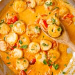 creamy garlic scallops in skillet with wooden spoon