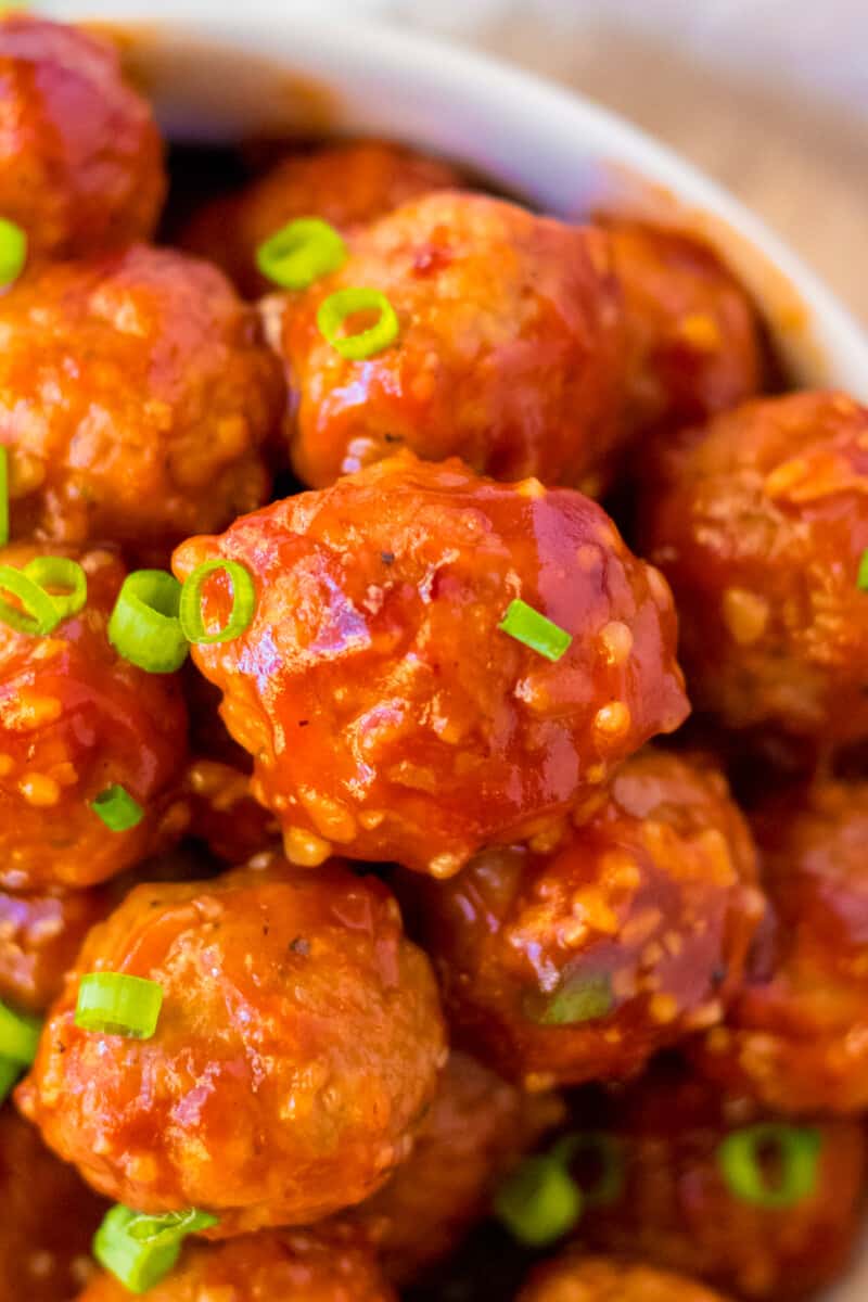 up close honey garlic meatballs garnished with green onion