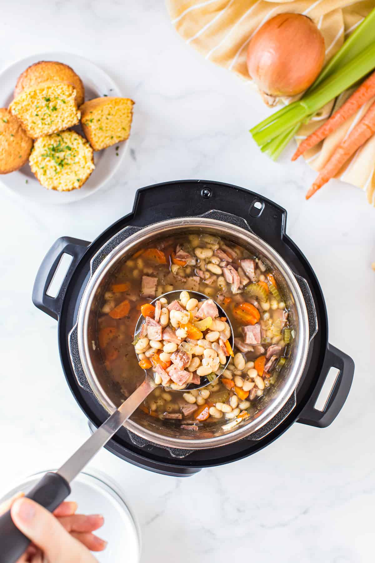 ladle picking up ham and bean soup from instant pot