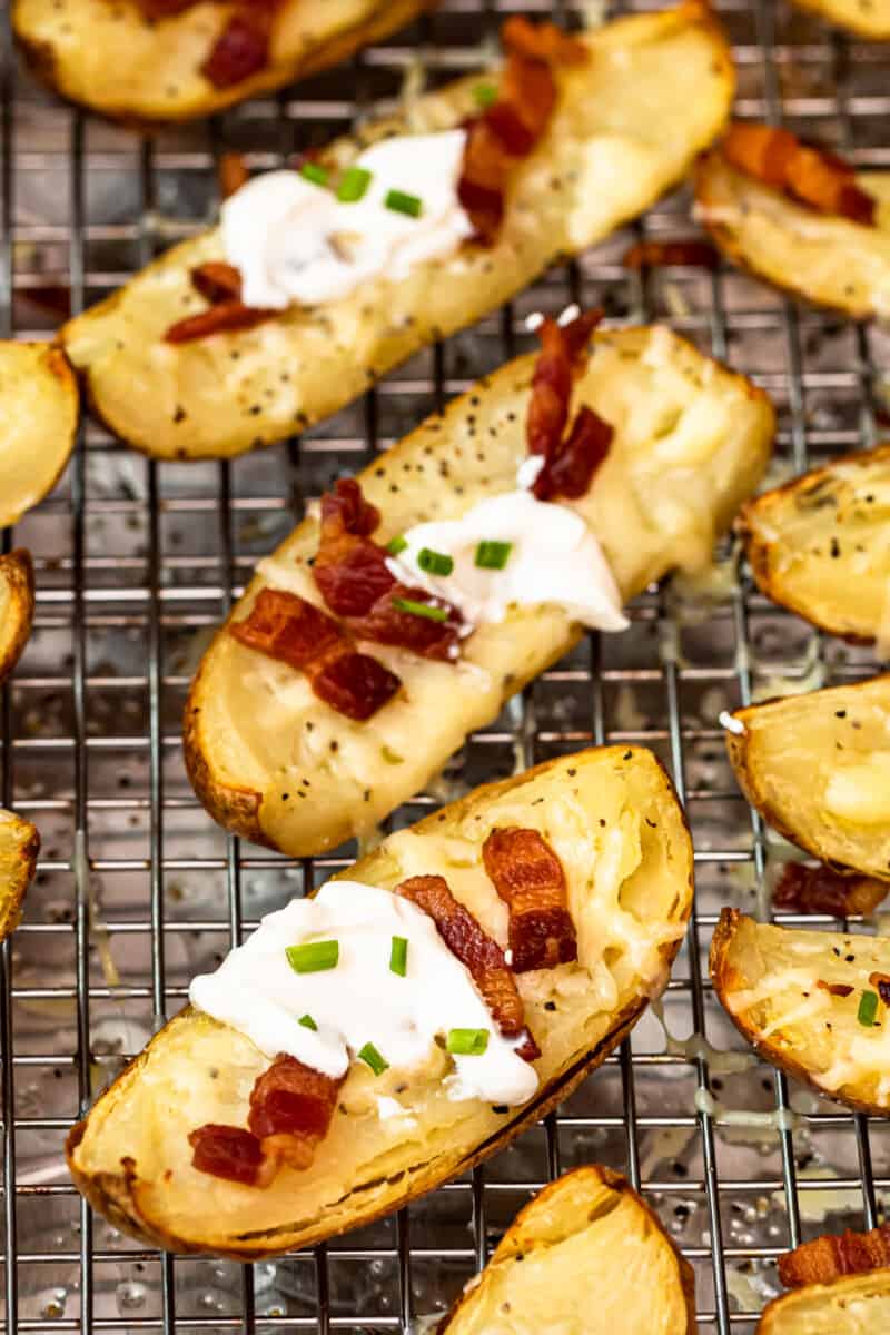 up close potato skins on baking sheet with sour cream, bacon, and chives