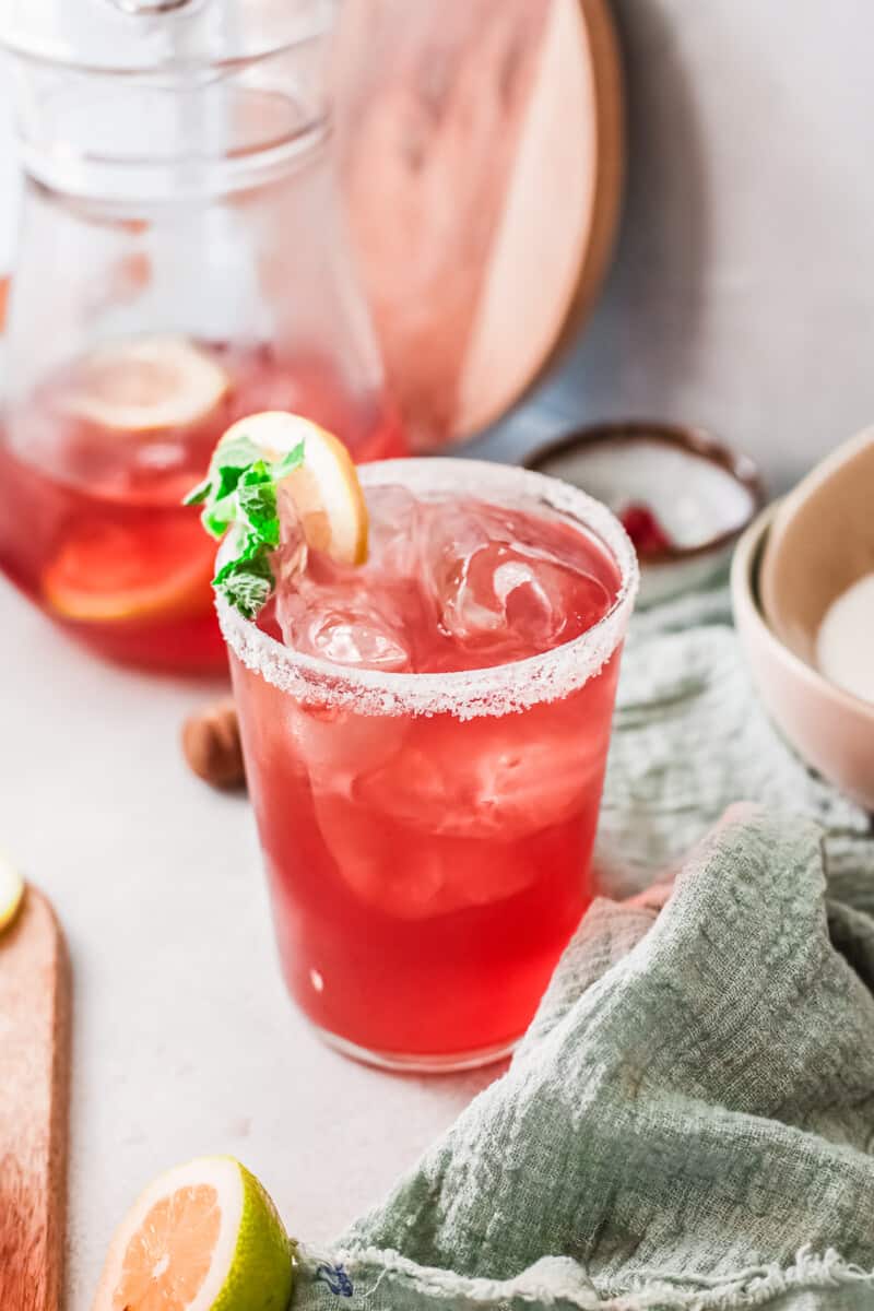 a red margarita in a cup with a salt rim.