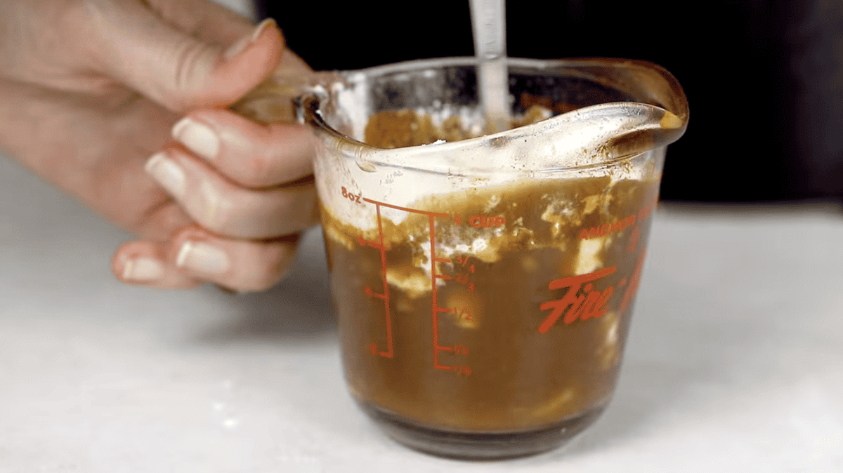 mixing a slurry in a measuring cup with a spoon.