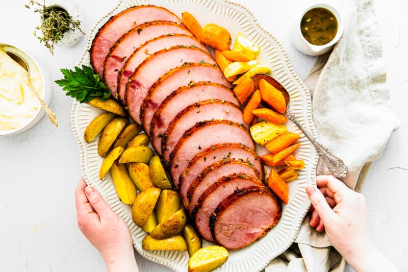 sliced air fryer ham with garlic herb butter on platter