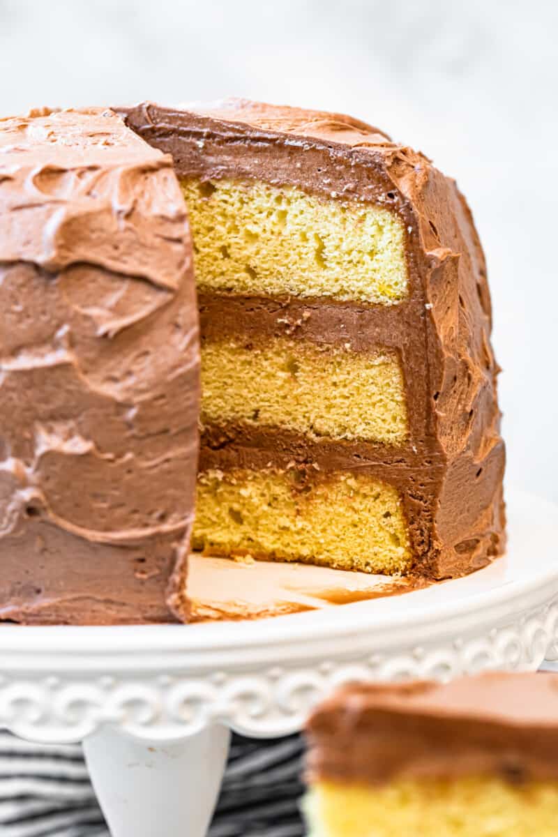 yellow layer cake with milk chocolate buttercream on cake stand