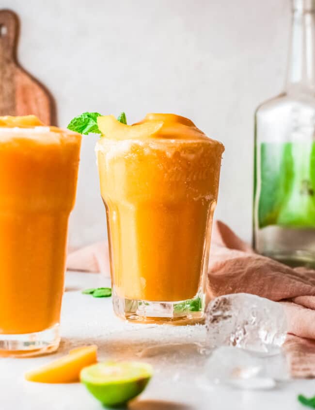 two glasses of frozen peach margaritas