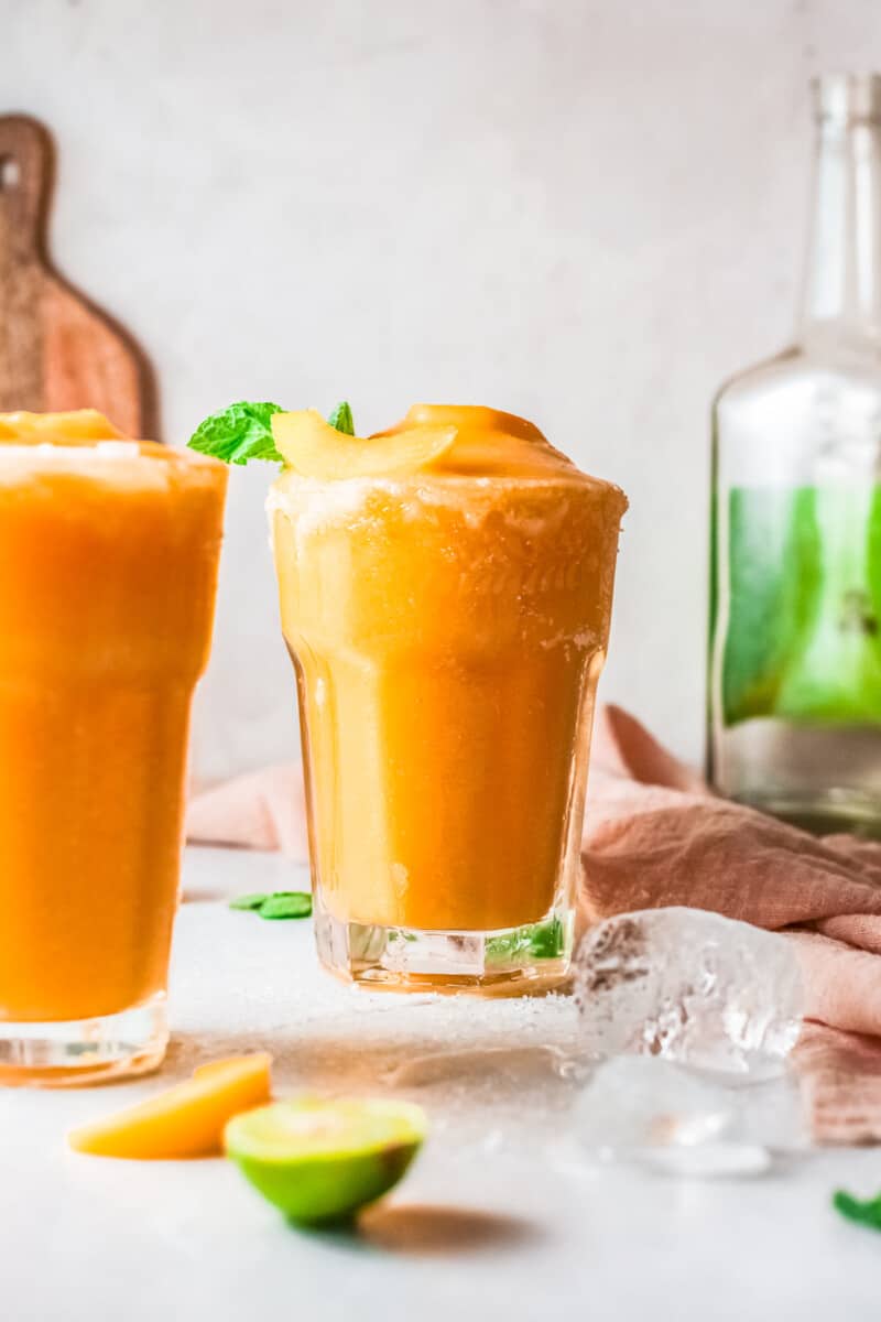 two glasses of frozen peach margaritas